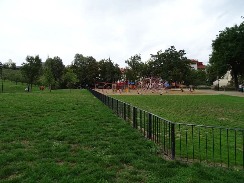 Dětské hřiště s lanovou pyramidou a houpačkami v pražském parku pod Petřínem