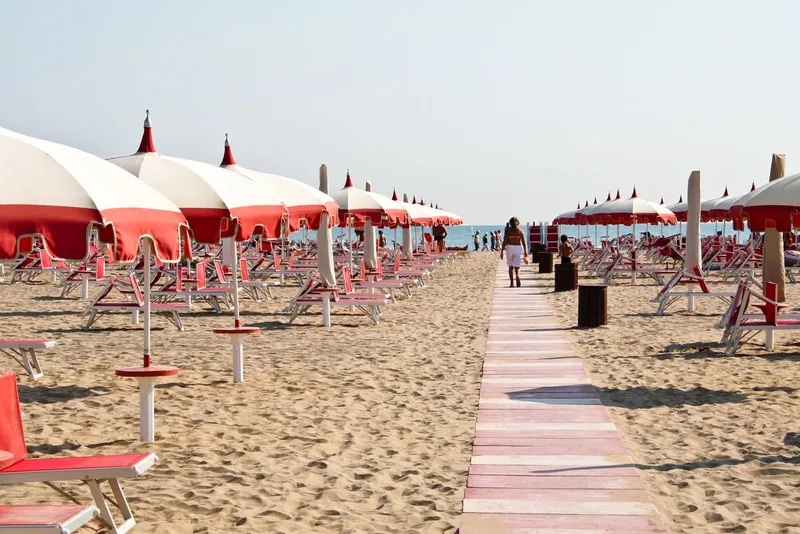 Sandy Rimini beach with striped umbrellas, one of the best beaches for families in Italy