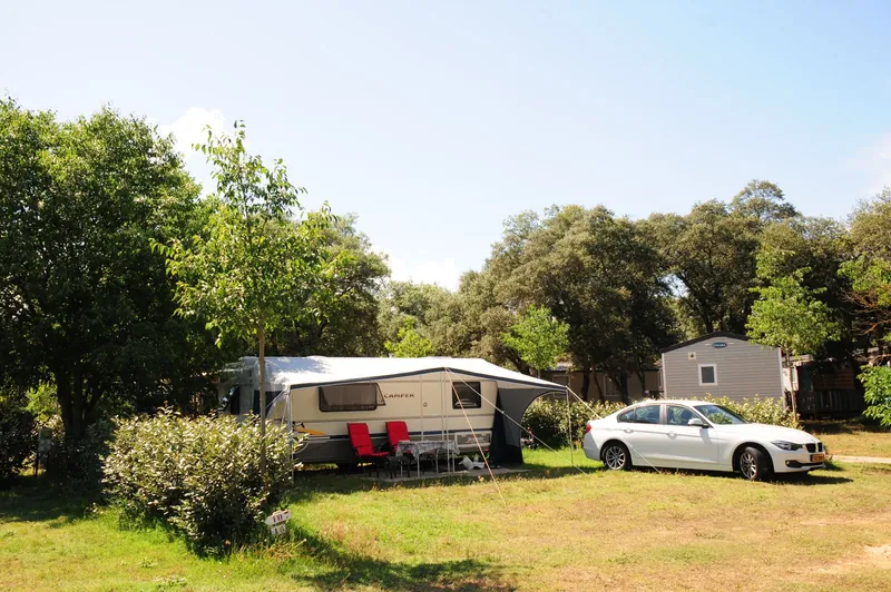 Caravan pitch and mobile homes under shady trees at a campsite in southern France, ideal for family camping