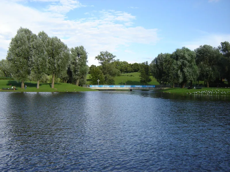 Olympic Lake and green lawns in Munich's Olympiapark in summer, one of the Euro 2024 fan zones with kids