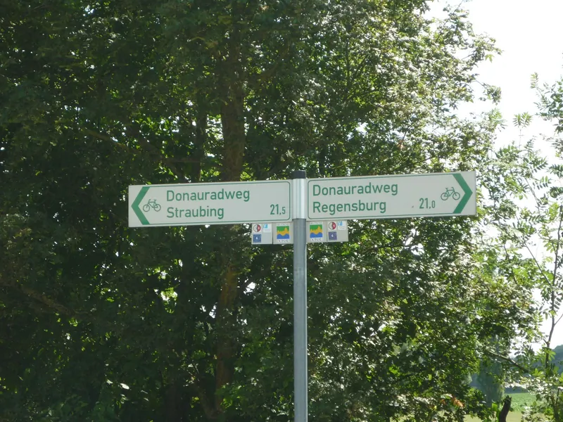 Danube Cycle Path signpost in green summer trees, the start of many cycling holidays with kids