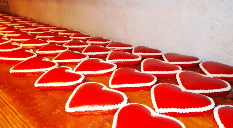 Rows of red iced gingerbread hearts, classic Christmas market food for kids