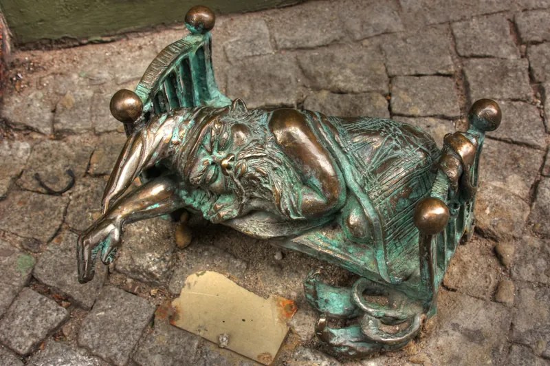 Wycieczka z dziećmi do Wrocławia: śpiący krasnal z brązu na bruku starówki
