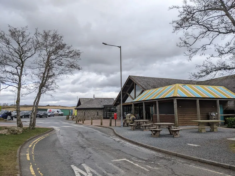 Stone farm shop building and picnic tables at Tebay Services on the M6, one of the best kid-friendly farm shops for a road trip