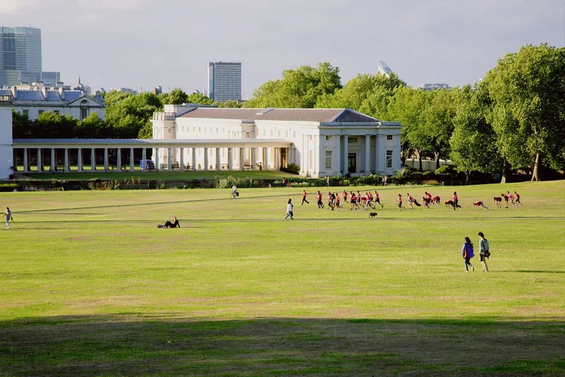 Walkers on the wide lawns of Greenwich Park below the National Maritime Museum, one of London's best family picnic spots
