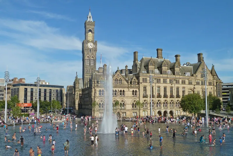 Families paddling in the City Park mirror pool in front of City Hall, a highlight of Bradford with kids